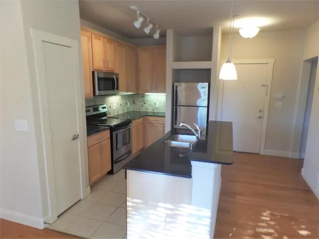a kitchen with stainless steel appliances granite countertop a refrigerator and a sink