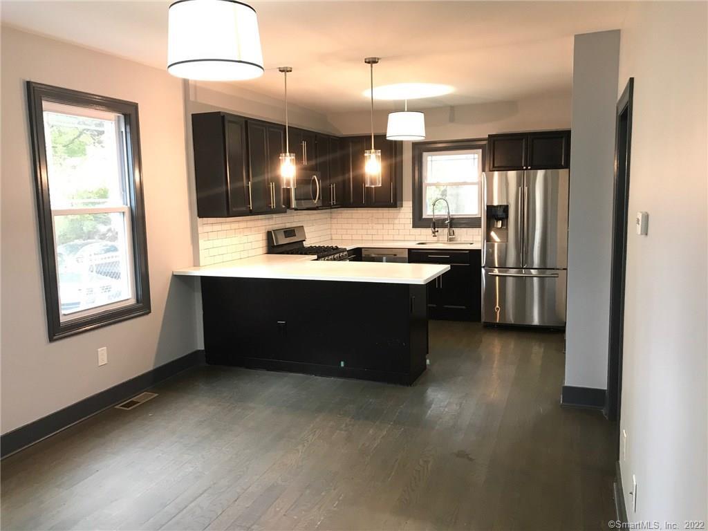 451 Hollister Avenue, Unit 1 Bridgeport, CT 06607 - Photo 1 of 1 a kitchen with kitchen island a sink stainless steel appliances and cabinets