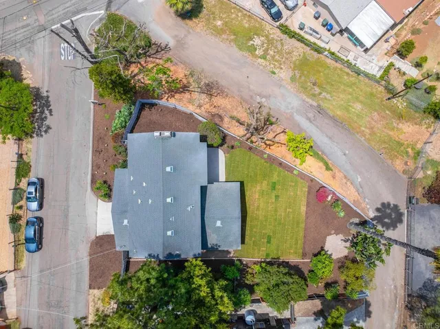 an aerial view of a house with a garden and lake view