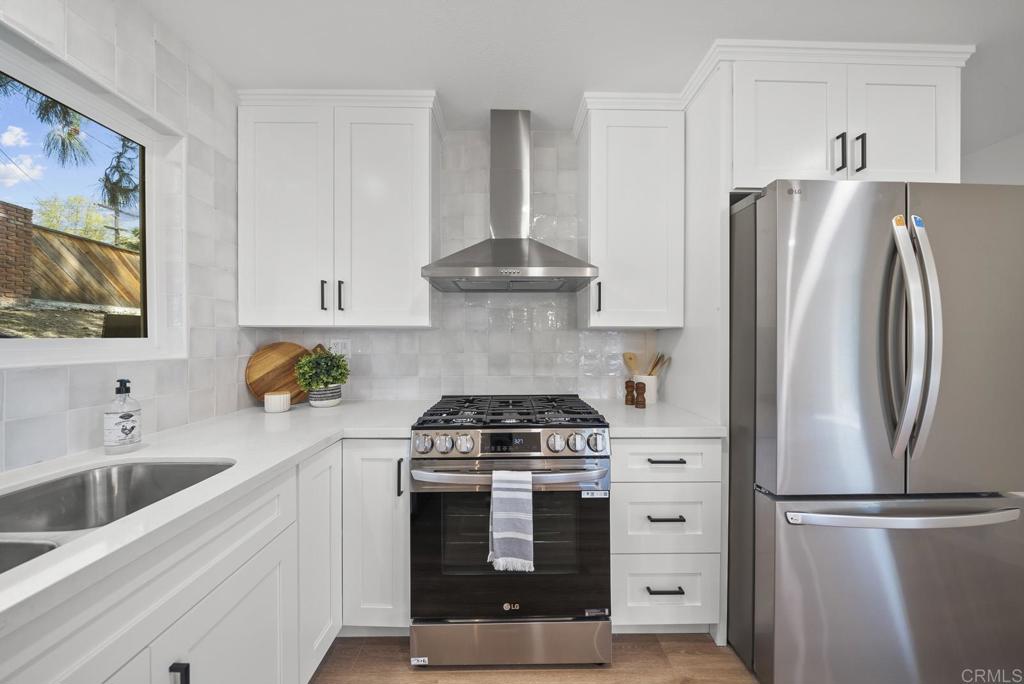 9306 Hollyhock Lane Spring Valley, CA 91977 - Photo 34 of 61 a kitchen with refrigerator a stove a sink and a window