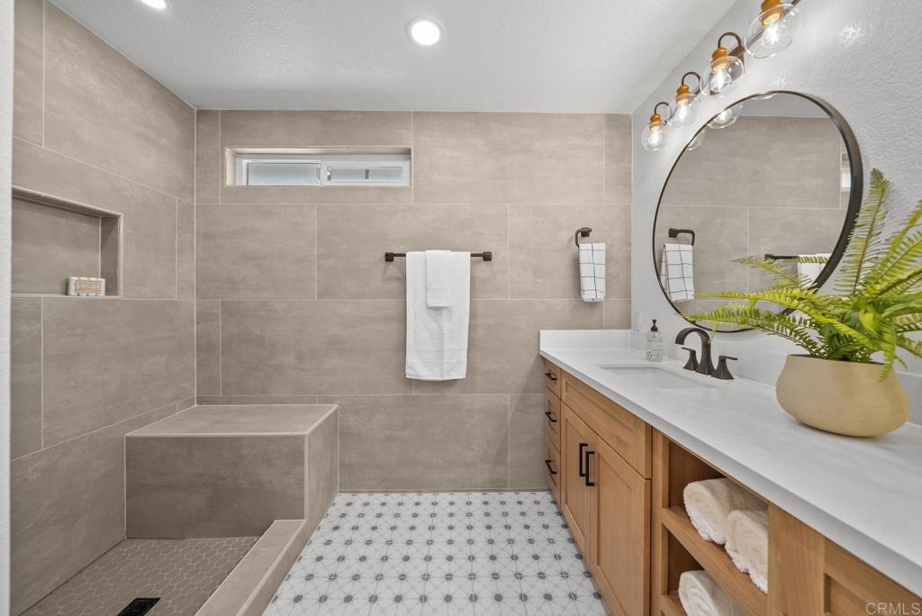9306 Hollyhock Lane Spring Valley, CA 91977 - Photo 46 of 61 a bathroom with a double vanity sink a toilet and a mirror