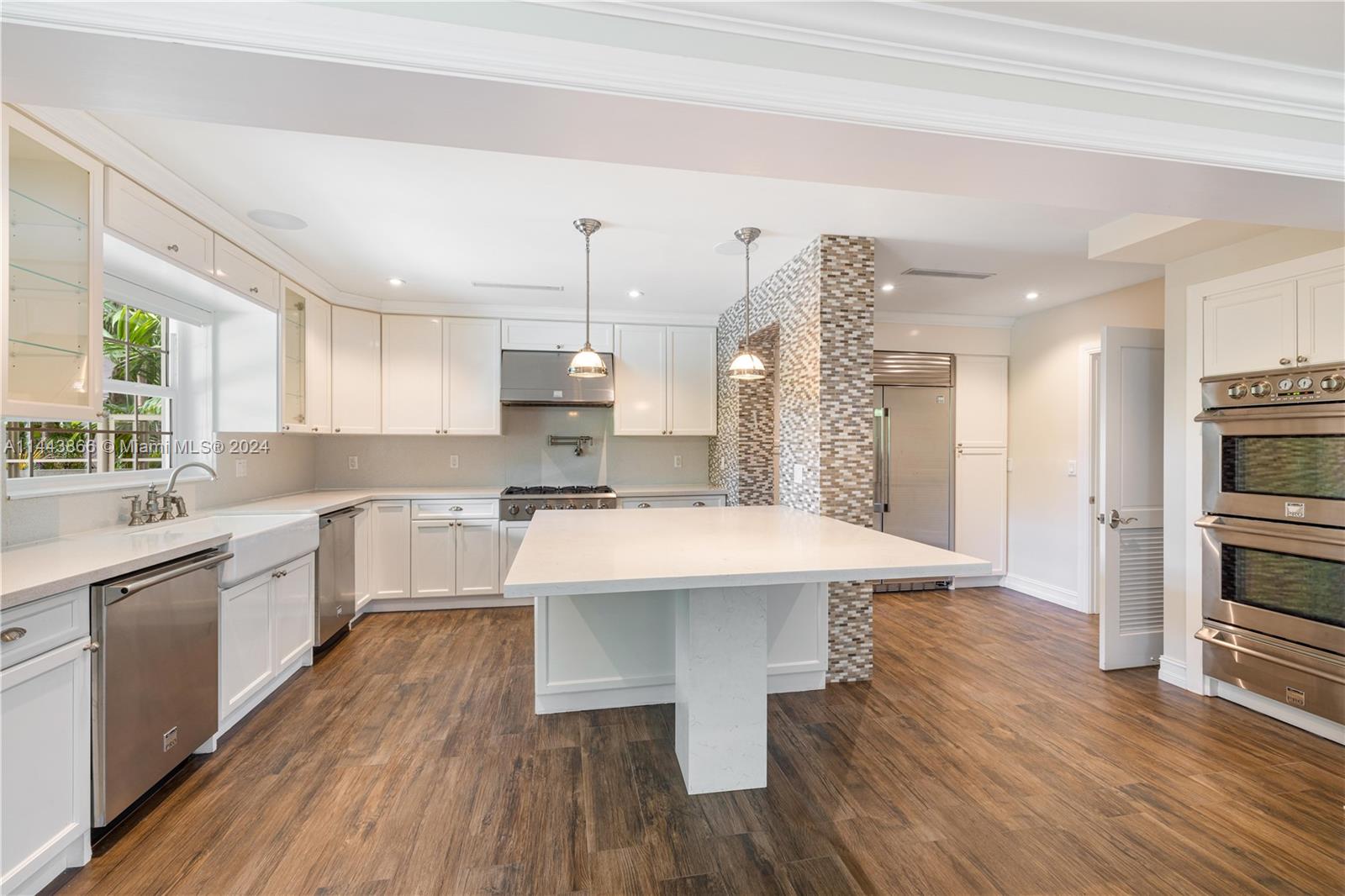 4531 North Bay Road Miami Beach, FL 33140 - Photo 5 of 40 a large kitchen with a center island wooden floor stainless steel appliances and windows