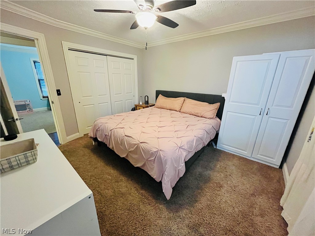 6871 Byron Road Madison, OH 44057 - Photo 37 of 48 Bedroom featuring dark colored carpet, crown molding, a closet, and ceiling fan