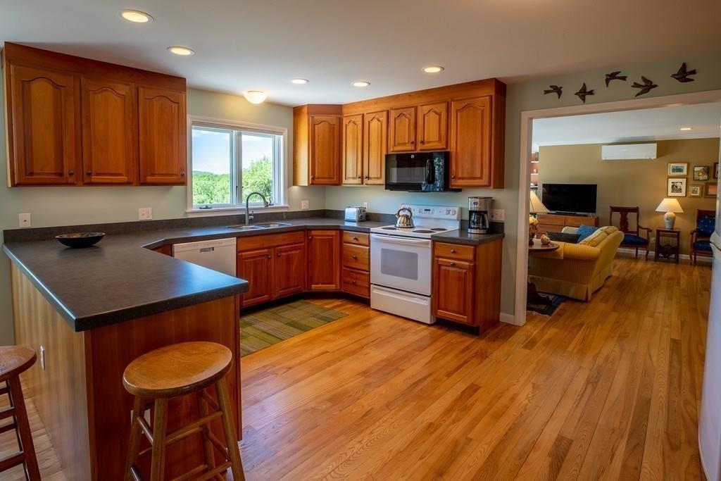 411 West Leyden Road Leyden, MA 01337 - Photo 18 of 42 a kitchen with stainless steel appliances granite countertop wooden cabinets a sink dishwasher a stove and a refrigerator with wooden floor