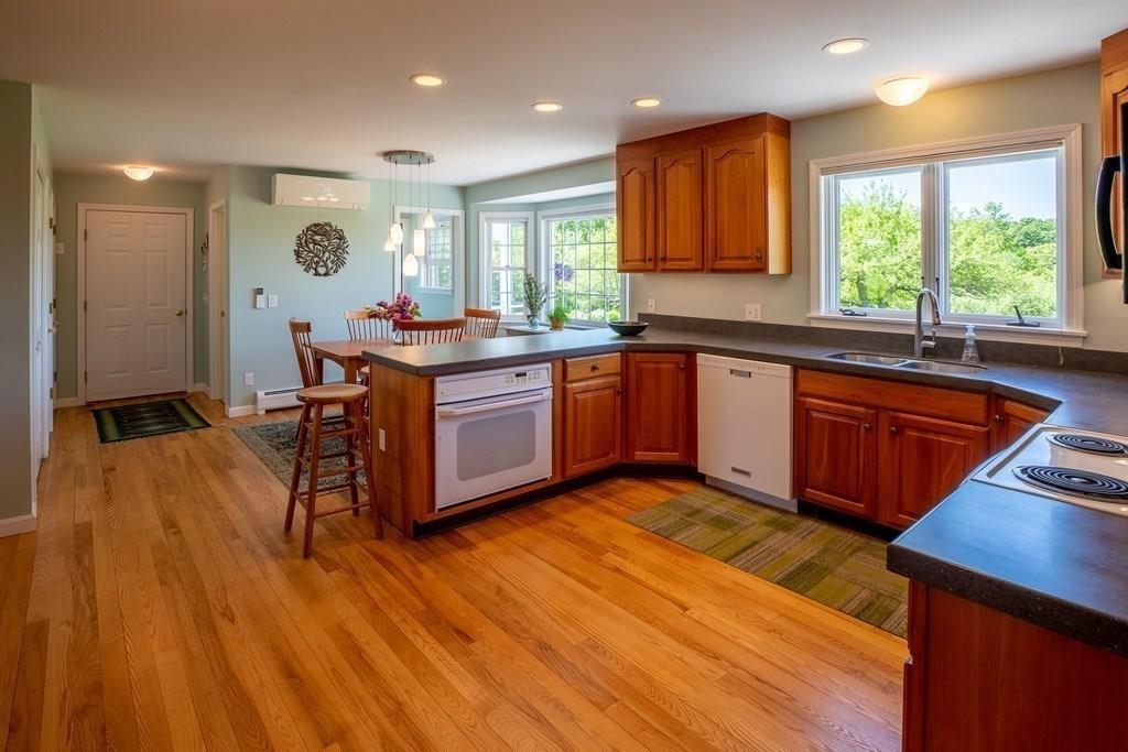 411 West Leyden Road Leyden, MA 01337 - Photo 19 of 42 a kitchen with stainless steel appliances granite countertop wooden floors and white cabinets
