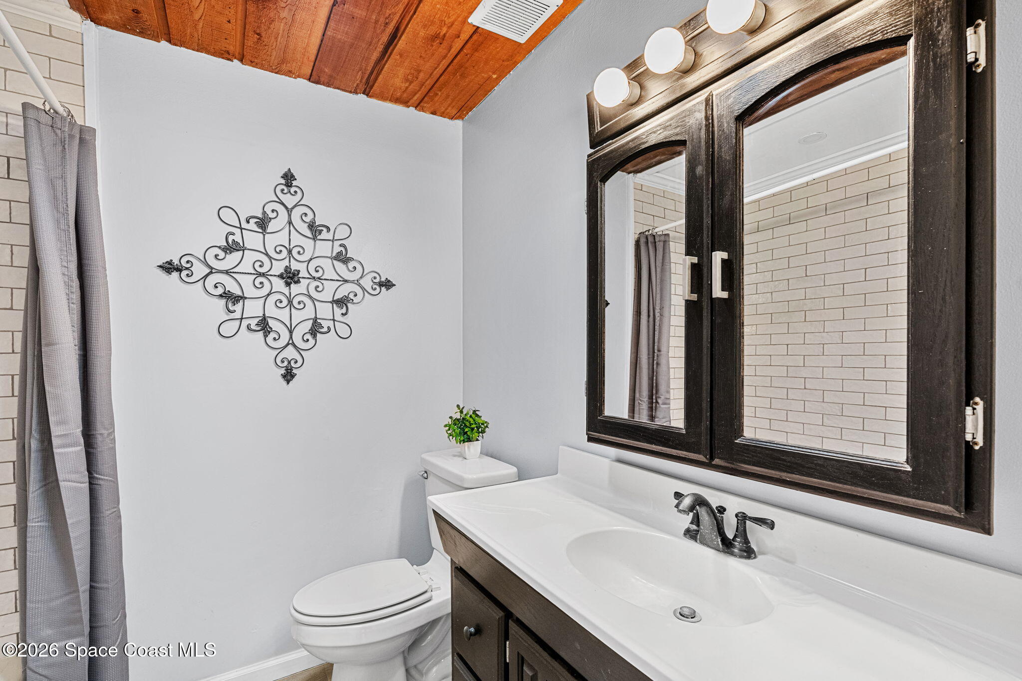 975 Oak Street Merritt Island, FL 32953 - Photo 32 of 76 a bathroom with a toilet sink and mirror