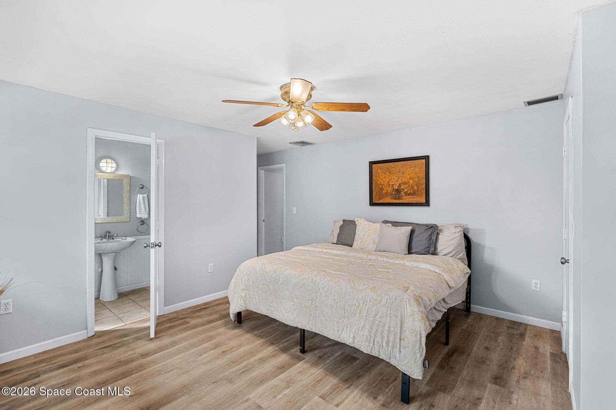 975 Oak Street Merritt Island, FL 32953 - Photo 37 of 76 a bedroom with a bed and a chandelier