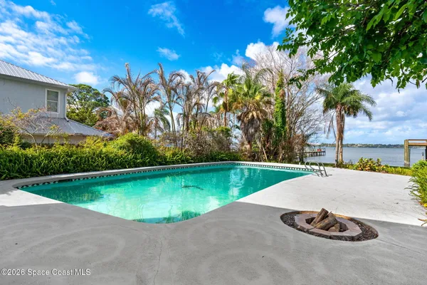 an aerial view of a house with outdoor space and a lake view in back