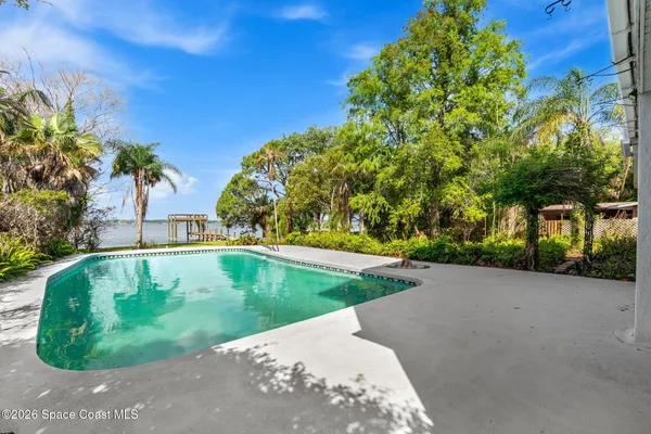 an aerial view of a residential houses with outdoor space and lake view