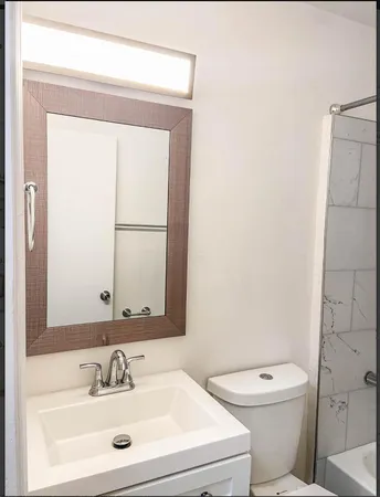 a bathroom with a toilet sink and mirror