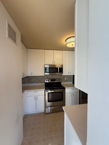 a kitchen with granite countertop a stove and a microwave