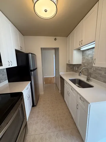 a kitchen with stainless steel appliances a sink stove and refrigerator