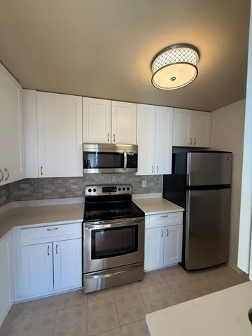 a kitchen with cabinets stainless steel appliances and a counter space