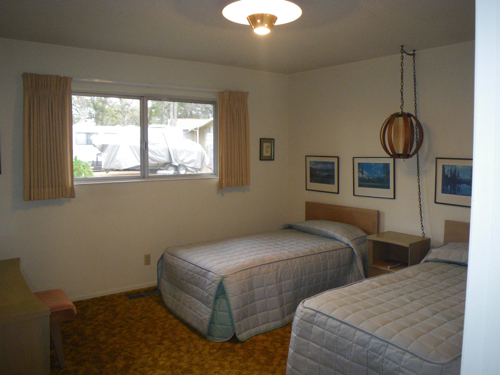 8815 Valley View Road Redding, CA 96001 - Photo 12 of 25 a bedroom with two beds and a chandelier