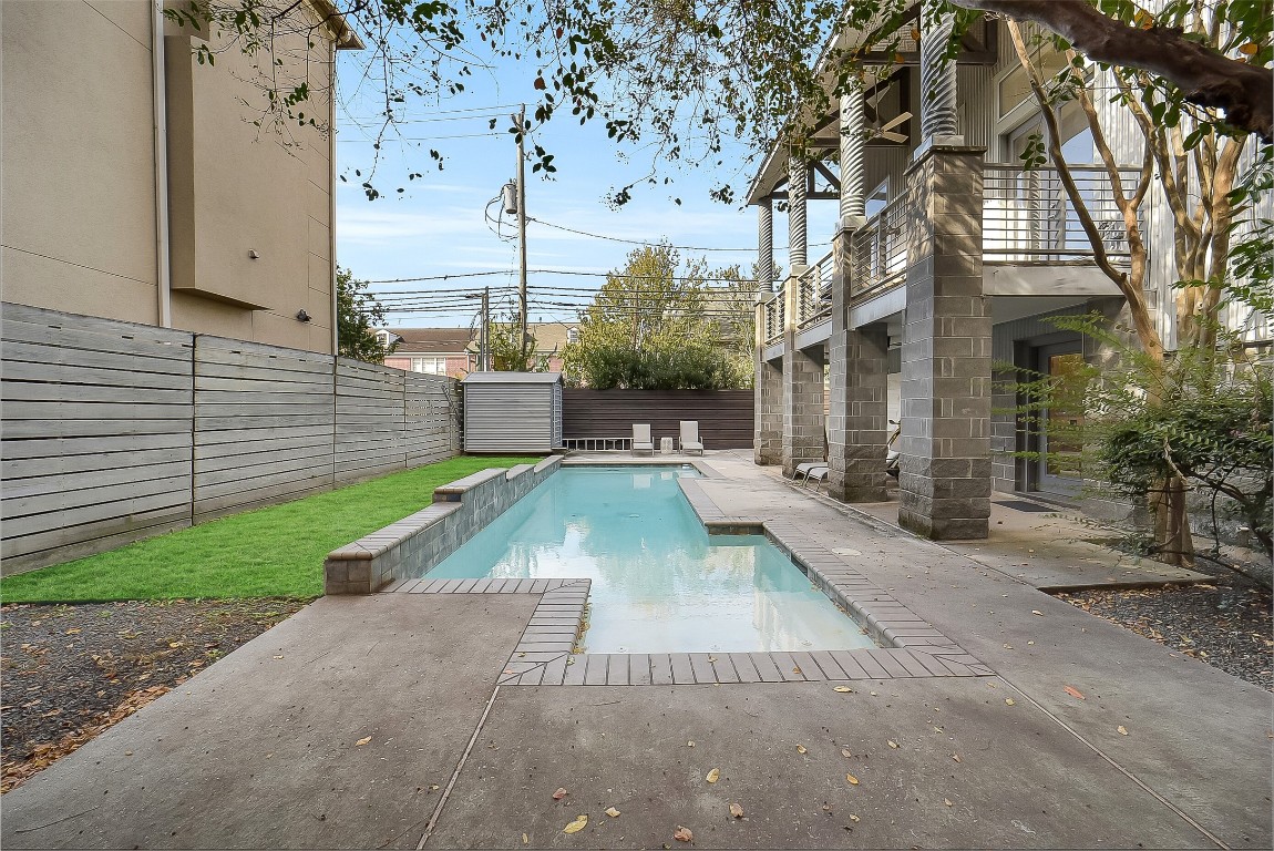 320 Detering Street Houston, TX 77007 - Photo 25 of 32 Incredible backyard with a fabulous private pool and adjacent green space to the left. Yard and pool maintenance are included in the rent. Covered patio area offers additional outdoor space for seating. Plenty of patio space for pool loungers. Fully fenced backyard—ideal for relaxing, dining, and enjoying outdoor living.
