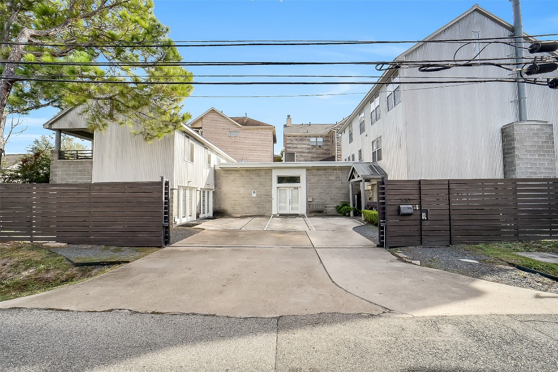 320 Detering Street Houston, TX 77007 - Photo 27 of 32 View from the front exterior showing the connected neighboring unit. Privacy with gated access and two dedicated parking spaces within gate. Property is located on the right-hand side.