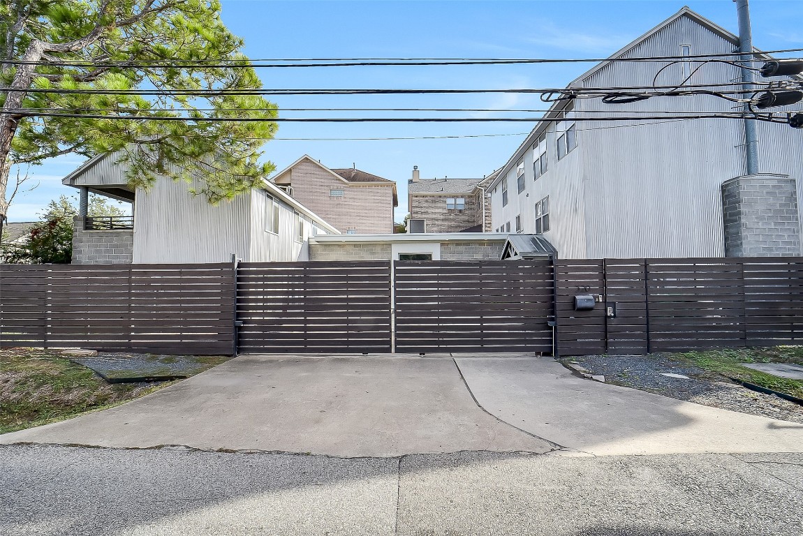320 Detering Street Houston, TX 77007 - Photo 28 of 32 Street view of the residence with the front privacy fence closed, highlighting the secure, gated entry. Location in a prime spot in desirable Rice Military.