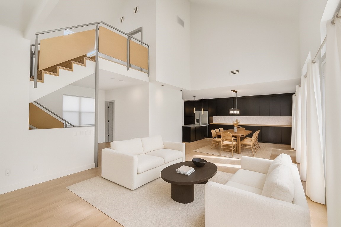 320 Detering Street Houston, TX 77007 - Photo 29 of 32 One more view of the second-floor living area looking toward the dining and kitchen spaces, featuring an open floor plan ideal for everyday living and entertaining. New wood flooring (’25) continues throughout. Staircase leads to the private third-floor primary suite, offering a functional and well-connected floor plan.