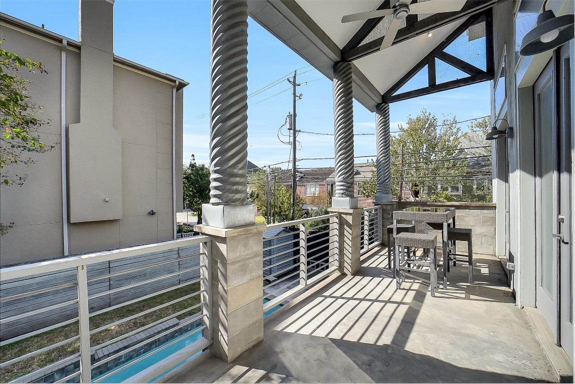 320 Detering Street Houston, TX 77007 - Photo 7 of 32 Balcony located off of the 2nd floor living, overlooking the backyard and pool area, features plenty of space for a dining table and chairs. Metal railing frames the space, while an outdoor ceiling fan and sconces by the French doors provide comfort and ambient lighting. Spacious area; Ideal for outdoor dining or relaxing.