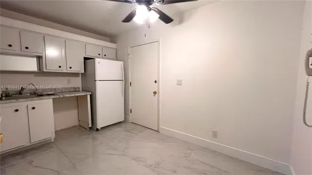 a kitchen with stainless steel appliances a refrigerator sink and white cabinets