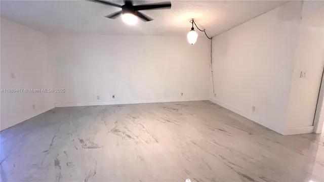 an empty room with a ceiling fan and window