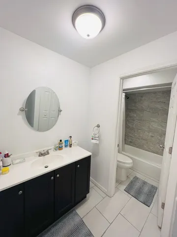 a bathroom with a double vanity sink a toilet and a mirror
