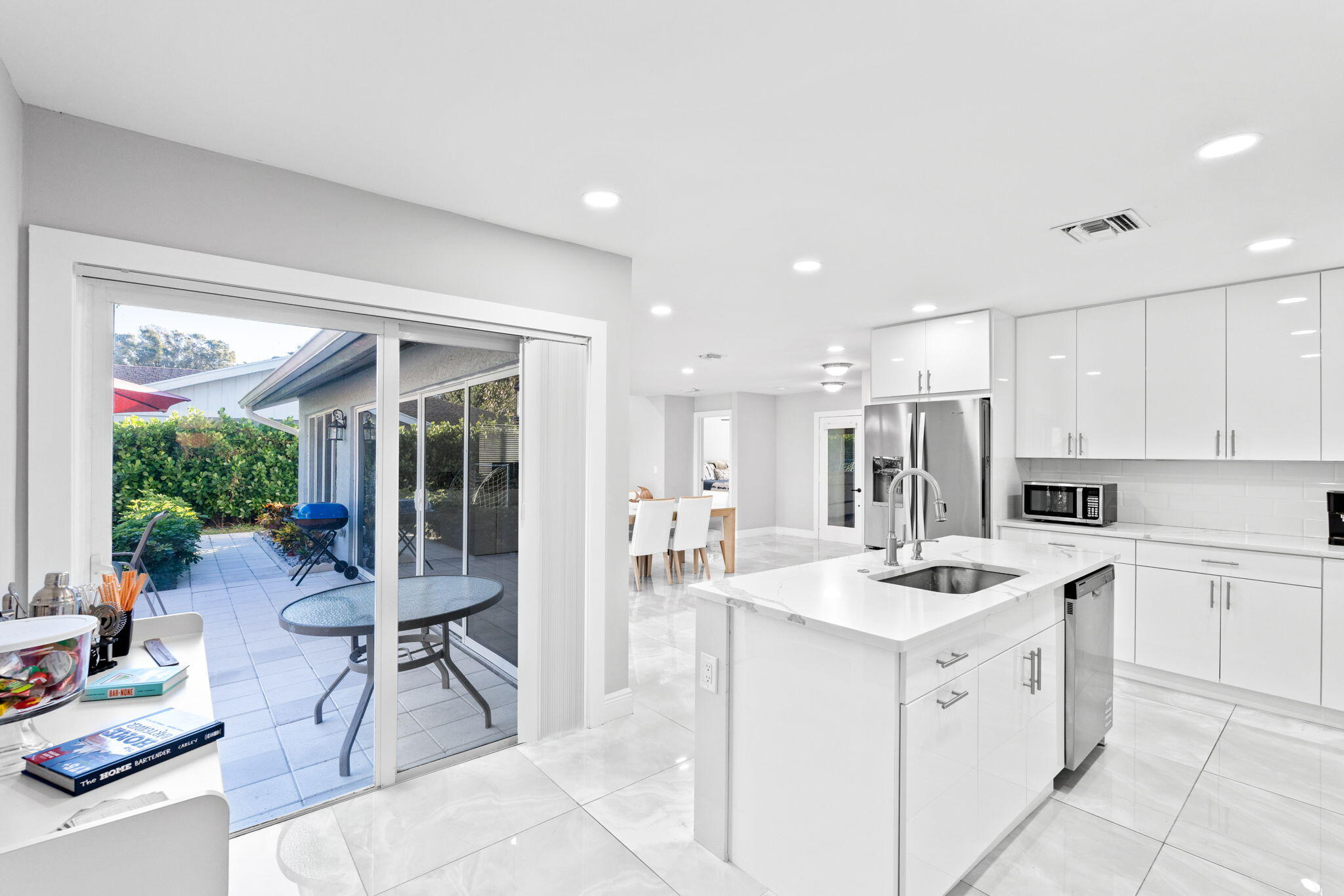12293 Old Country Road South Wellington, FL 33414 - Photo 12 of 32 a kitchen with a sink chairs and white cabinets