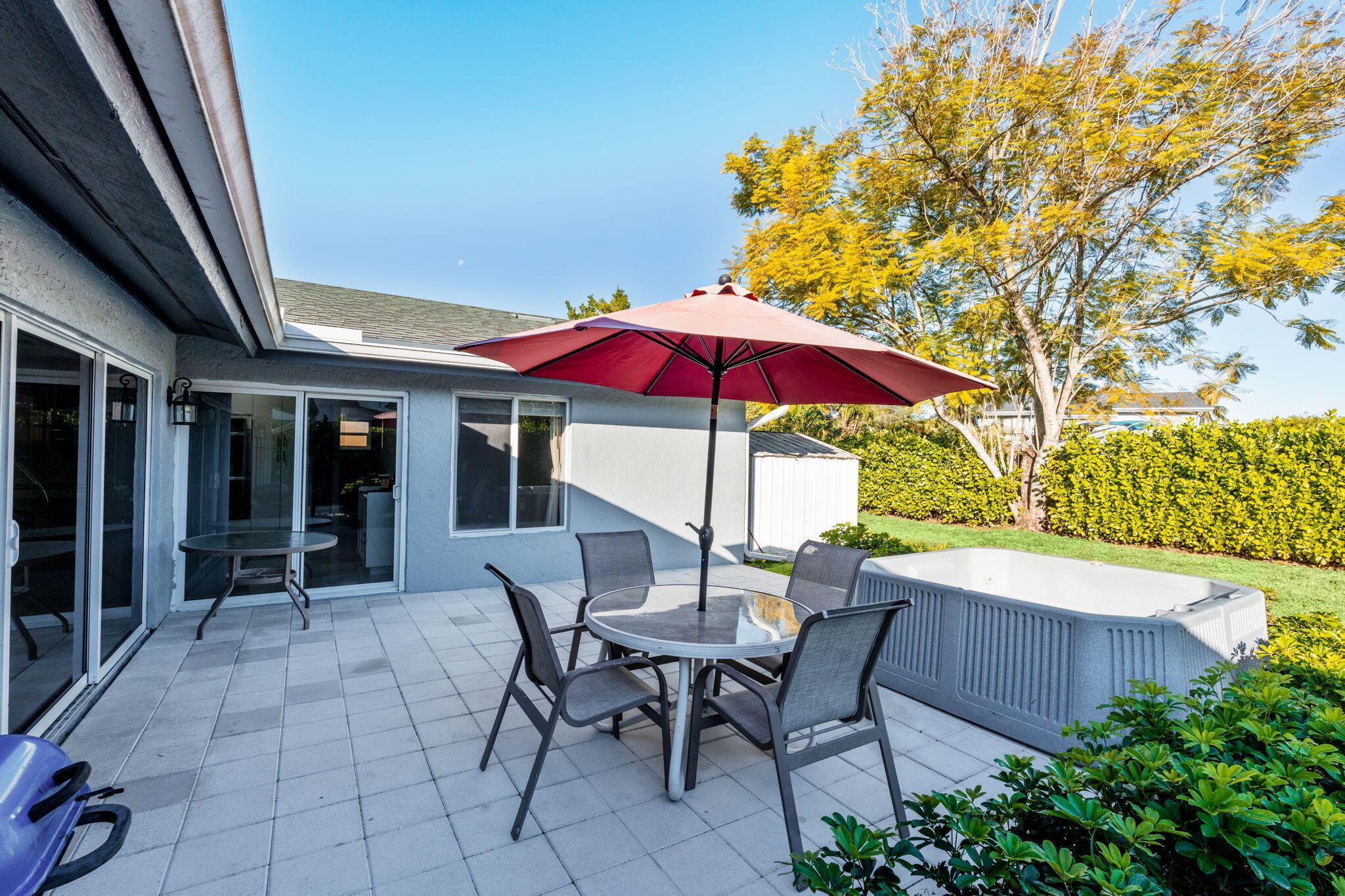 12293 Old Country Road South Wellington, FL 33414 - Photo 23 of 32 a patio with a table and chairs under an umbrella
