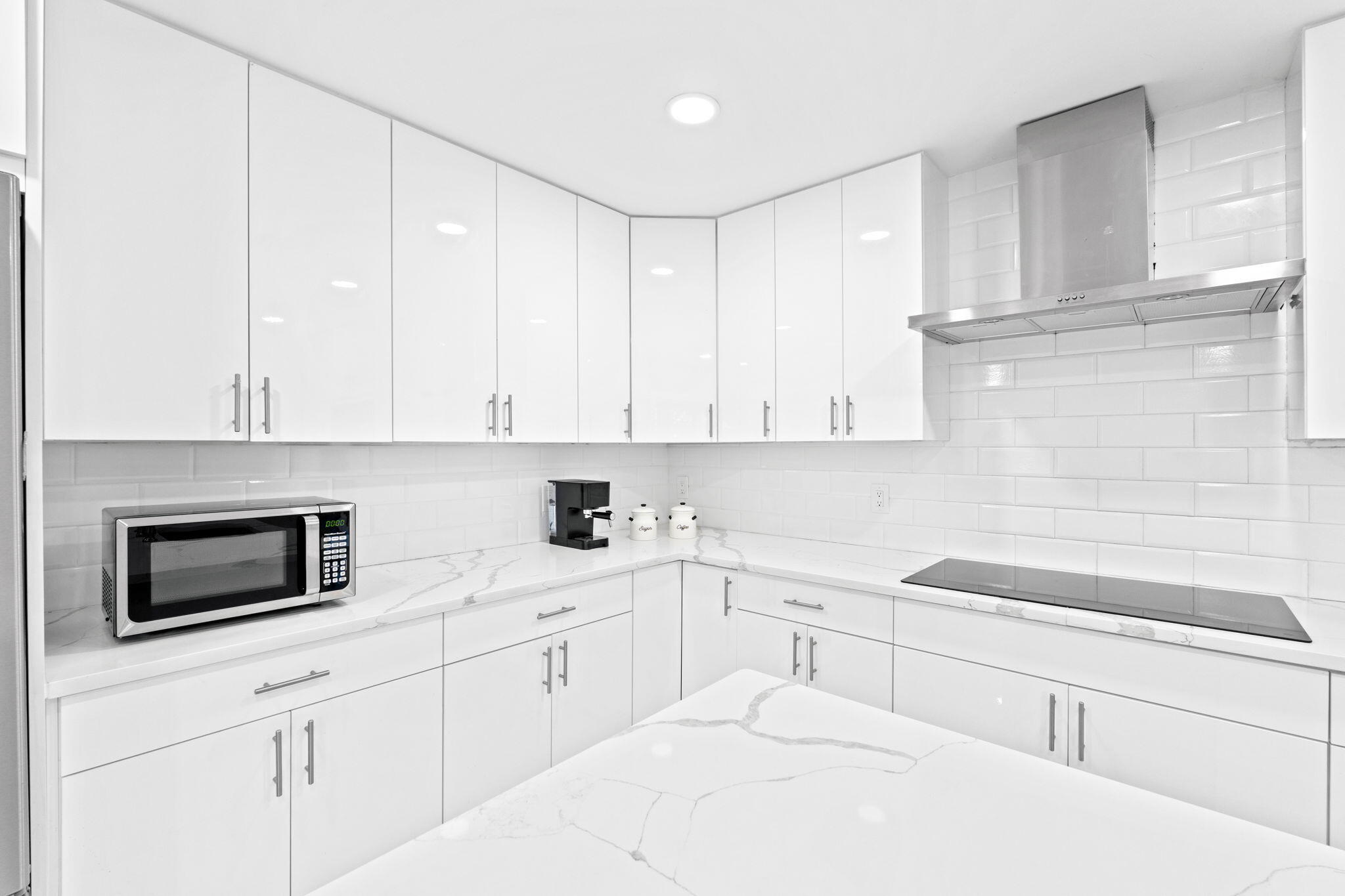 12293 Old Country Road South Wellington, FL 33414 - Photo 10 of 32 a kitchen with granite countertop white cabinets and white appliances