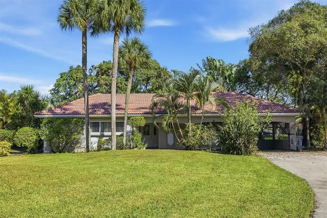 a front view of a house with a yard and potted plants