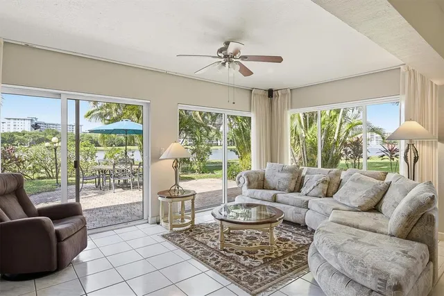 a view of a dining room with furniture a chandelier and large windows