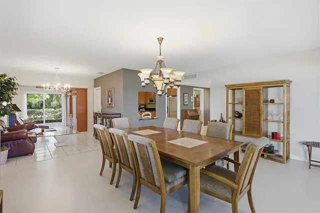 a living room with furniture a chandelier and a large window