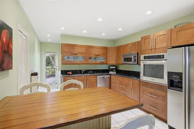 a kitchen with stainless steel appliances granite countertop a stove a sink and a microwave
