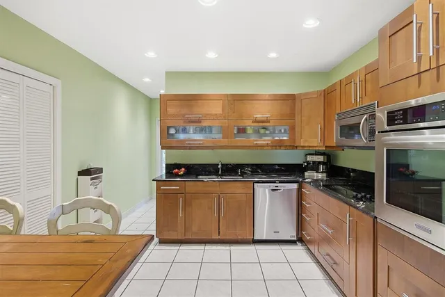 a kitchen with stainless steel appliances granite countertop a stove a sink and a refrigerator
