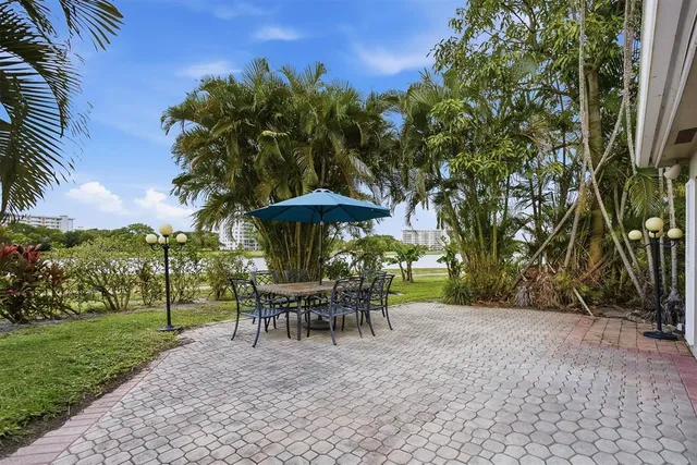 a view of a table and chairs under an umbrella in the garden