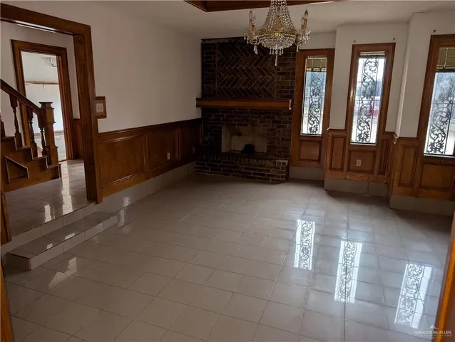 a view of an empty room with a fireplace and a window