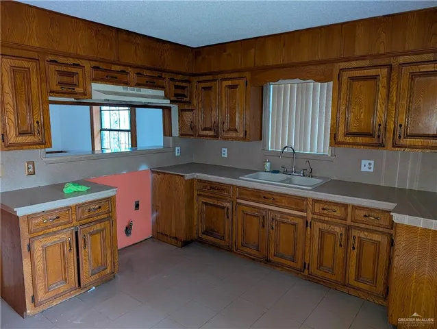 a kitchen that has a sink and a stove in it