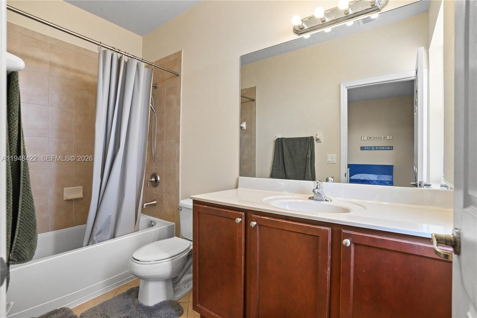 9105 Southwest 227th Street, Unit 9 Cutler Bay, FL 33190 - Photo 21 of 37 a bathroom with a sink a toilet a mirror and shower