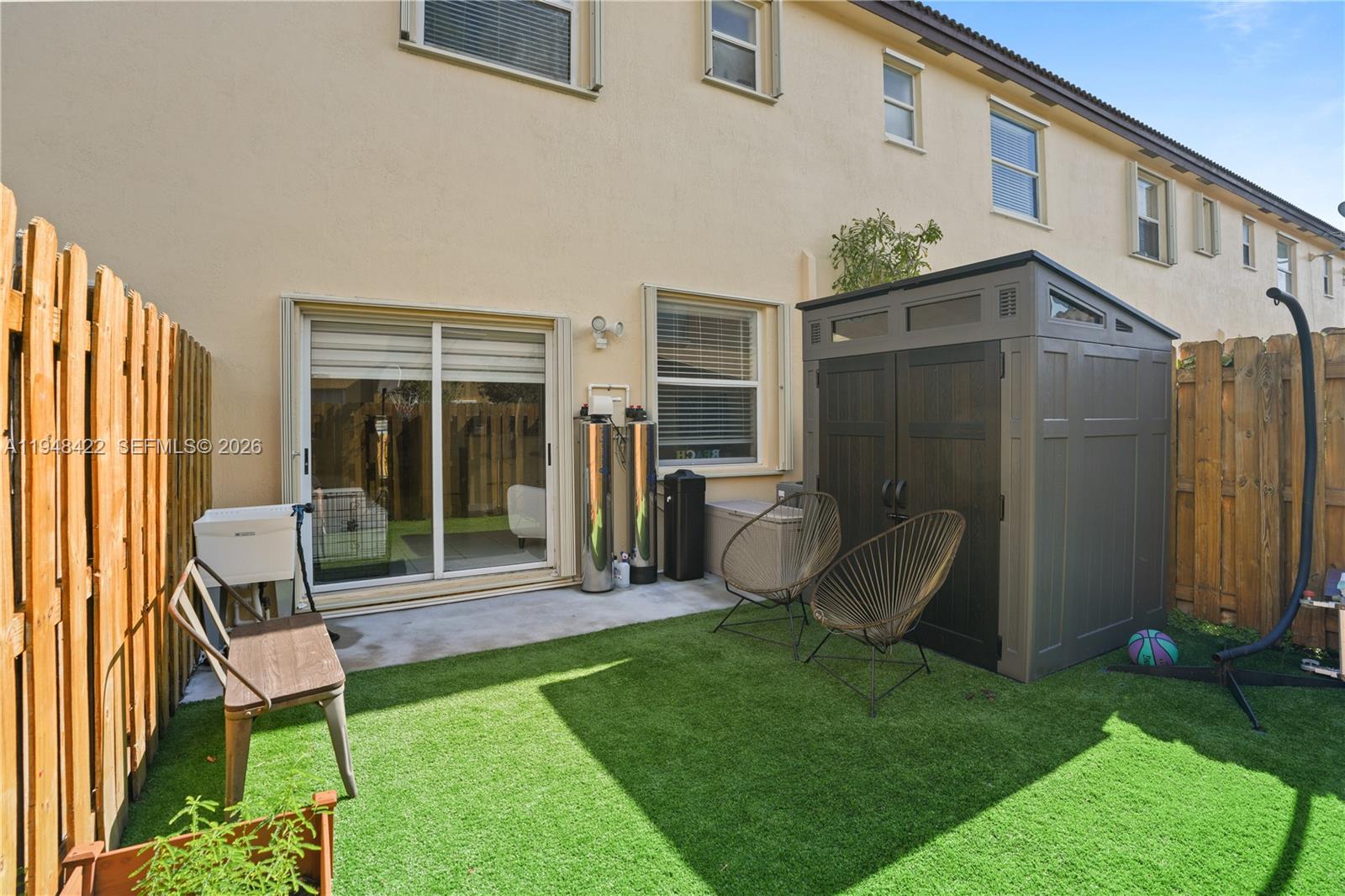 9105 Southwest 227th Street, Unit 9 Cutler Bay, FL 33190 - Photo 24 of 37 a view of a chair and table in backyard of the house