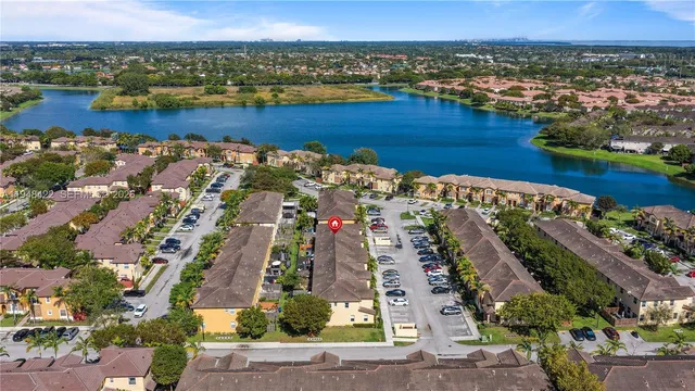 an aerial view of ocean and residential houses with outdoor space