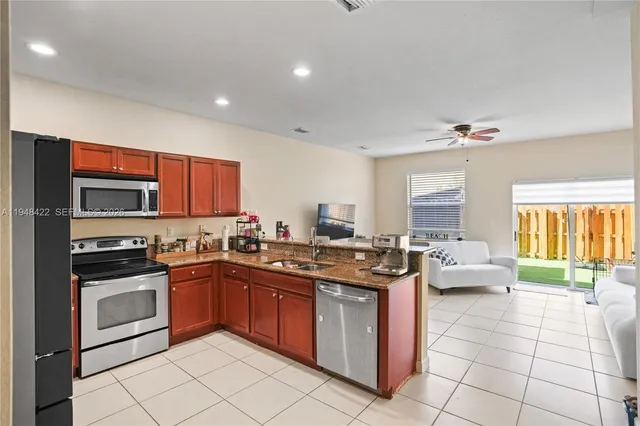 a kitchen with stainless steel appliances granite countertop a sink stove top oven and cabinets
