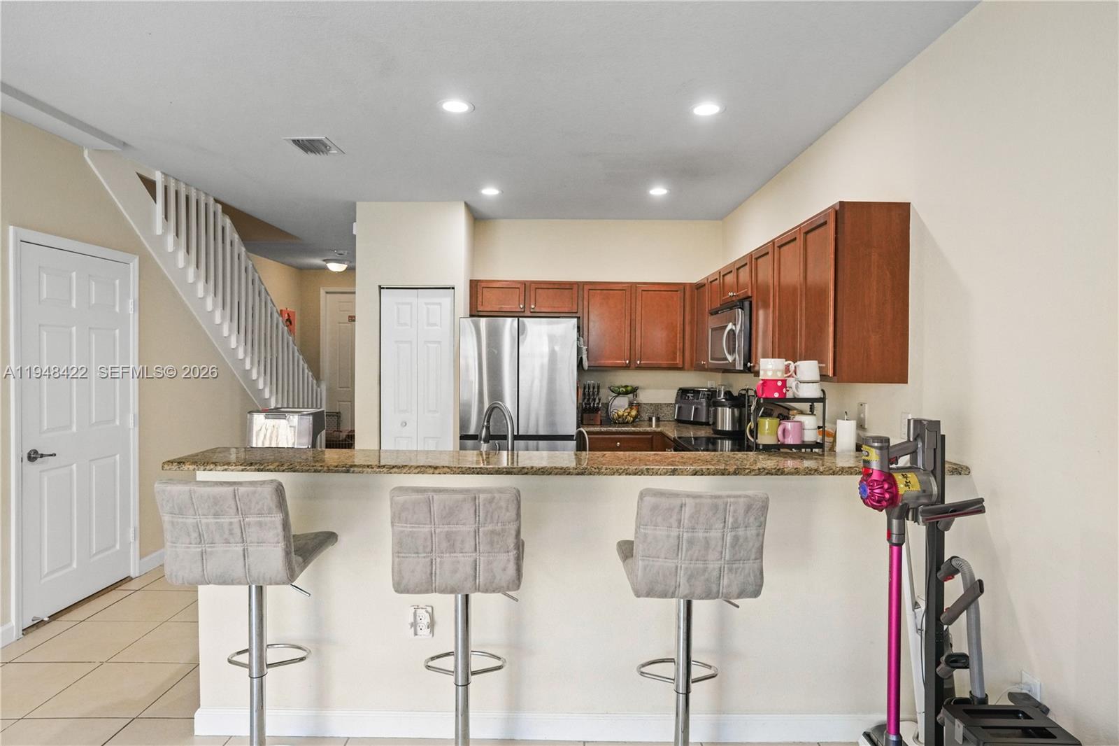 9105 Southwest 227th Street, Unit 9 Cutler Bay, FL 33190 - Photo 9 of 37 a kitchen with stainless steel appliances kitchen island granite countertop a refrigerator and microwave