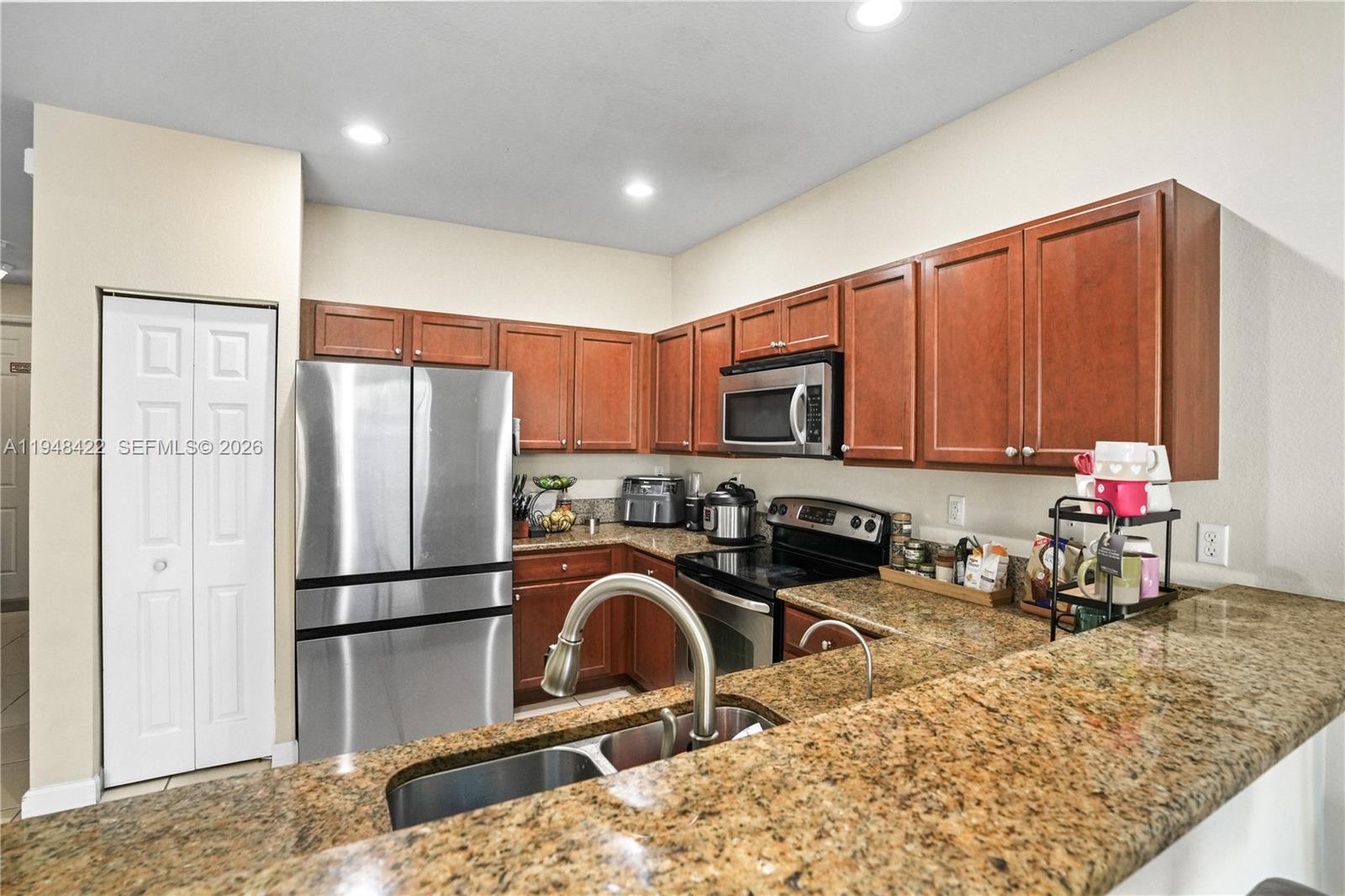9105 Southwest 227th Street, Unit 9 Cutler Bay, FL 33190 - Photo 10 of 37 a kitchen with stainless steel appliances granite countertop a refrigerator sink and stove