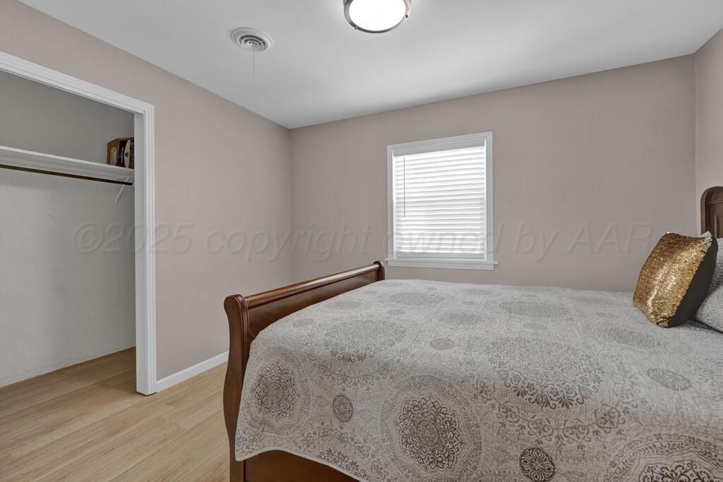 312 Southwest 45th Avenue Amarillo, TX 79110 - Photo 16 of 23 a bedroom with a bed and wooden floor