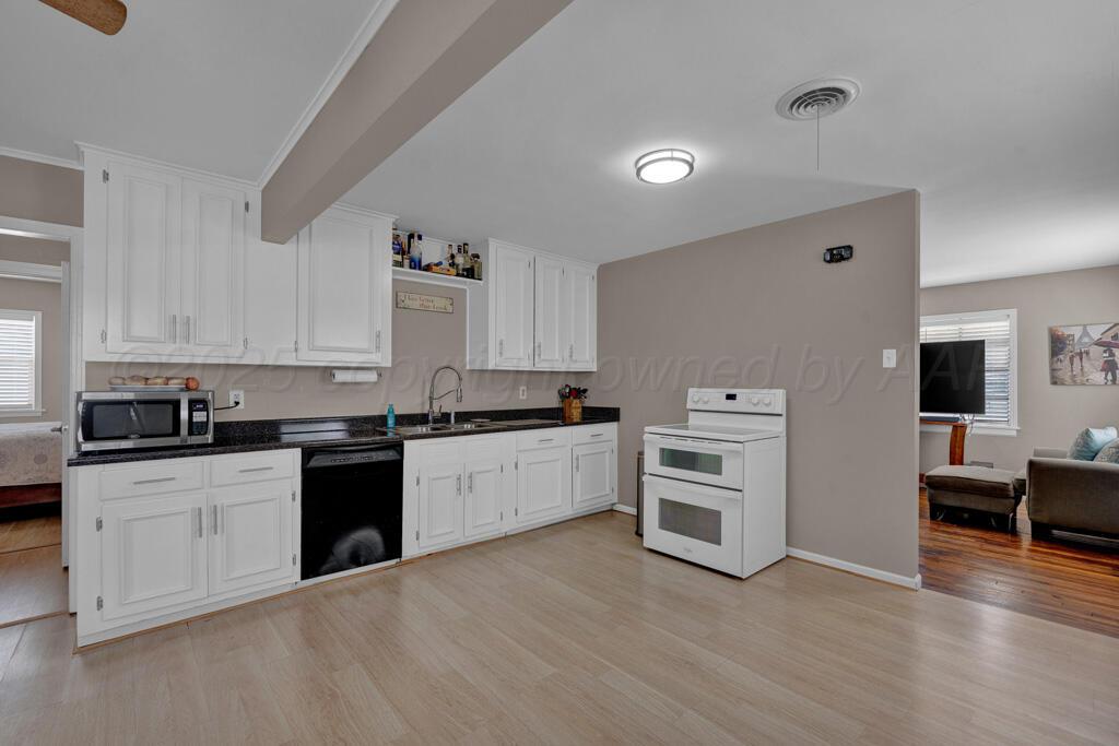 312 Southwest 45th Avenue Amarillo, TX 79110 - Photo 6 of 23 a kitchen with granite countertop a stove top oven and cabinets