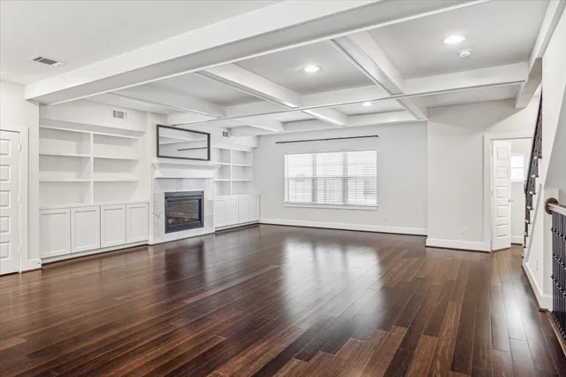 a view of an empty room with a fireplace and a window
