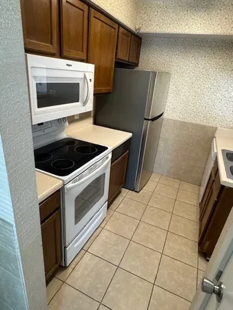 a kitchen with granite countertop a stove and a microwave