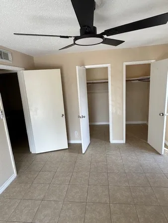 a view of a refrigerator in kitchen and an empty room