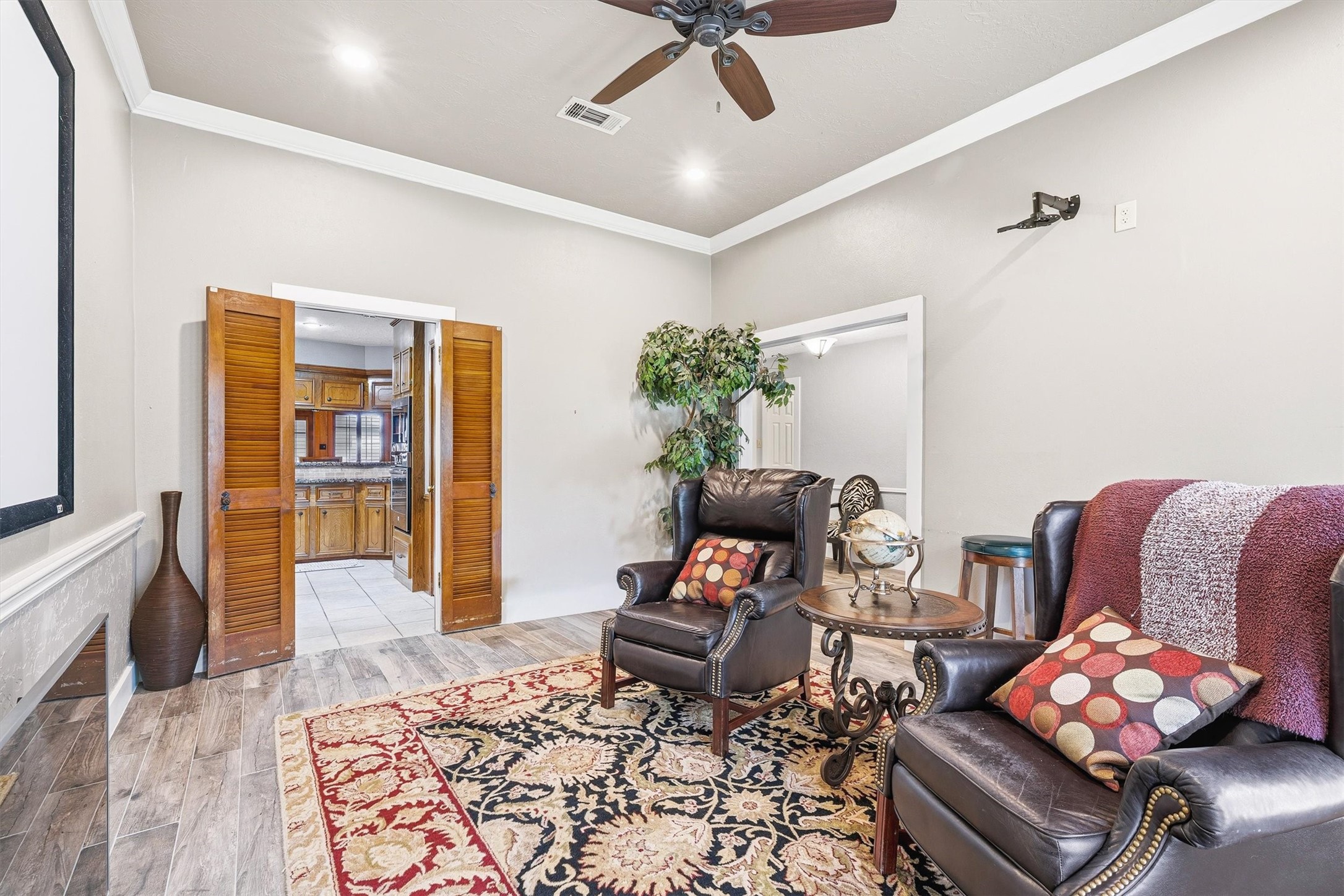 826 North Rivershire Drive Conroe, TX 77304 - Photo 11 of 46 This angle shows how seamlessly this flex room connects to the kitchen through those louvered doors — the layout makes entertaining easy and the flow between spaces feel natural and intentional.