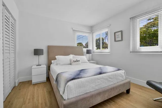 a bedroom with a bed and wooden floor